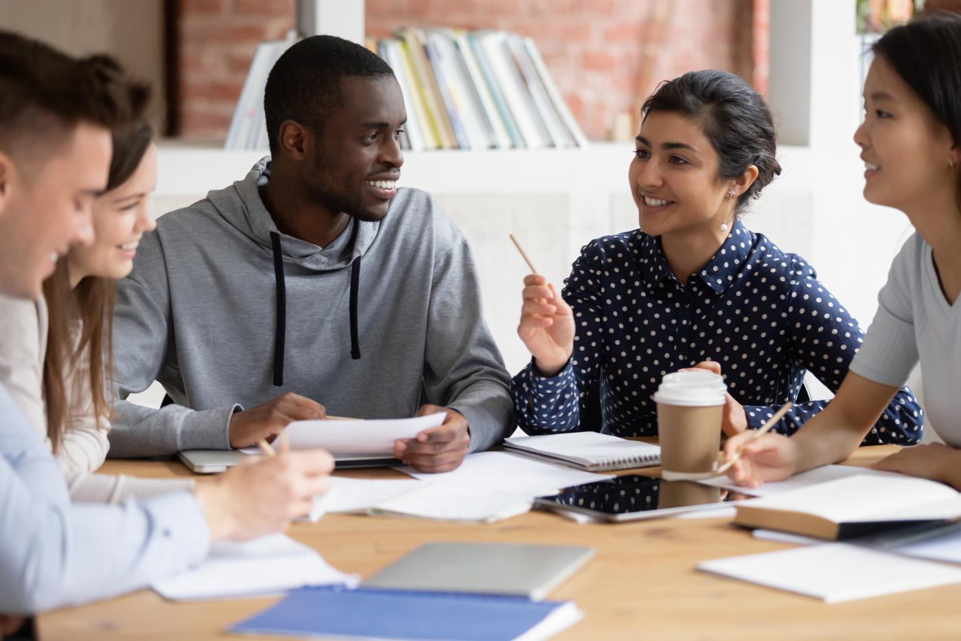 A group of students in discussion sitting around a table.